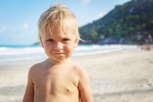 Portrait of a baby with a naked torso on the beach