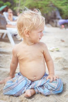 Portrait of a baby with a naked torso on the beach