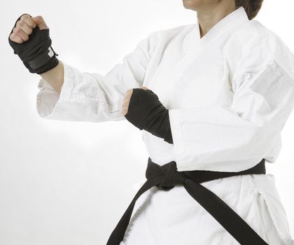 Close up of a woman dress in martial art clothing and black hand wrap