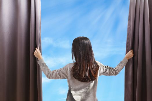 Asian portrait beautiful woman opening curtains on cloud sky background