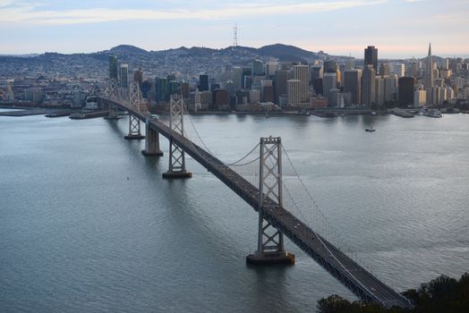 an aerial view of bay bridge near san francisco downtown during sunset, taken from a helicopter 