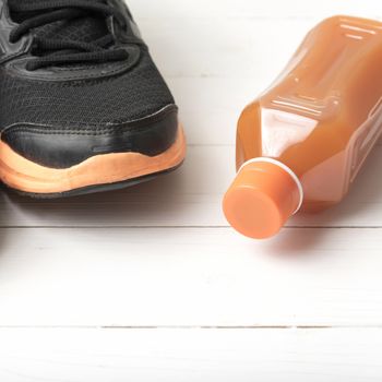 running shoes and orange juice on white wood table