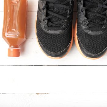 running shoes and orange juice on white wood table