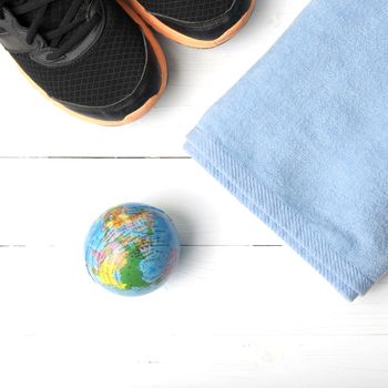 running shoes,towel and earth ball on white wood table concept world healthy