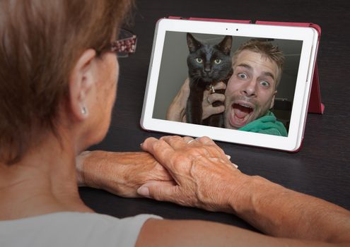 Senior woman with tablet contacting her family