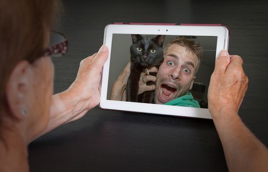 Senior woman with tablet contacting her family