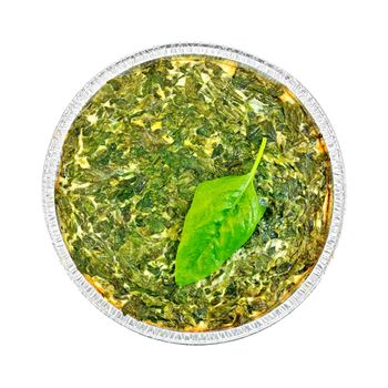 Celtic cake with spinach, tomatoes, oatmeal and eggs in baking dish from a foil, a sheet of spinach isolated on white background on top
