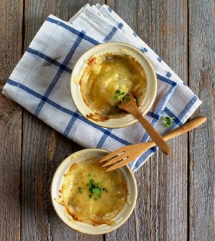 Ramekins with Delicious Champignon Mushroom on Checkered Napkin with Wooden Forks closeup Rustic Wooden background. Top View