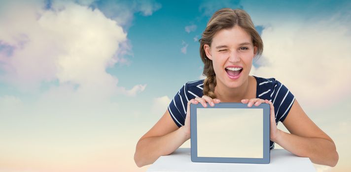 Woman showing tablet pc  against blue sky with white clouds
