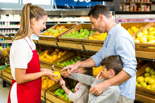 Happy family discussing with worker in grocery store 