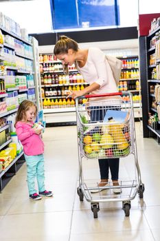 Mother and daughter doing shopping in grocery store 