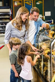 Happy family looking at bread in grocery store 