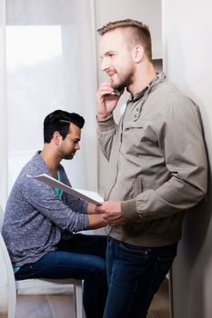 Happy gay couple working in office