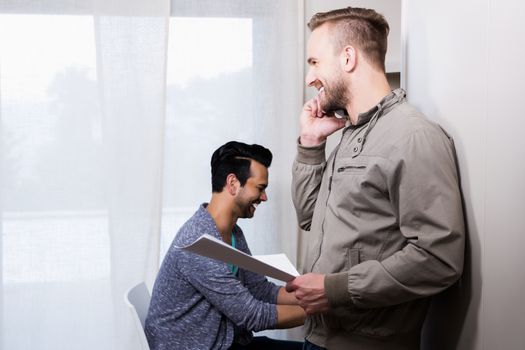 Happy gay couple working in office