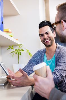 Happy gay couple using tablet at home