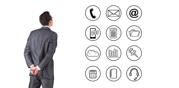 Businessman in grey suit looking against telephone apps icons 