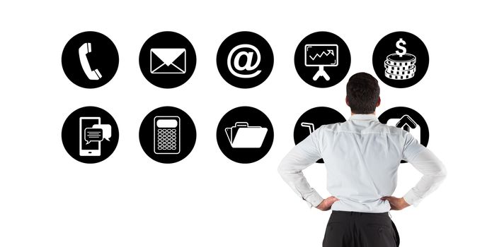 Businessman standing back to the camera with hands on hips against telephone apps icons 