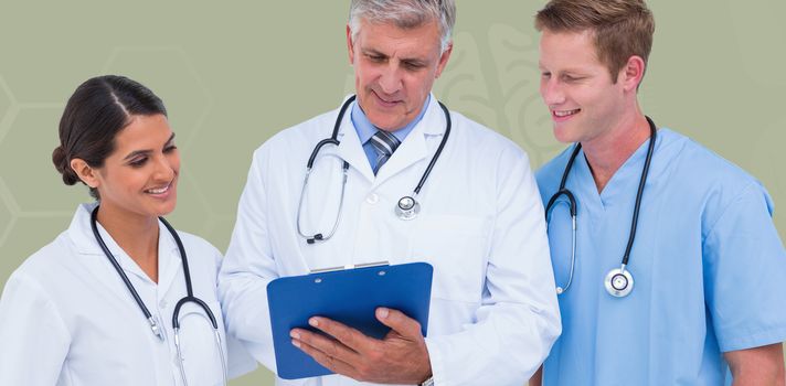Doctor working with colleagues while holding writing pad  against blue