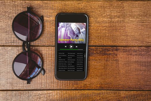 Music app against view of glasses and a smartphone
