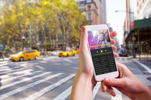 Hand holding smartphone against music app