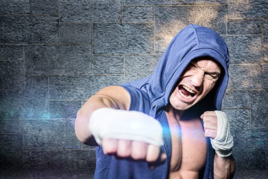 Aggressive fighter punching against black background against grey