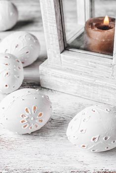 Easter eggs with cut out pattern by hand on light background.The photograph high key.