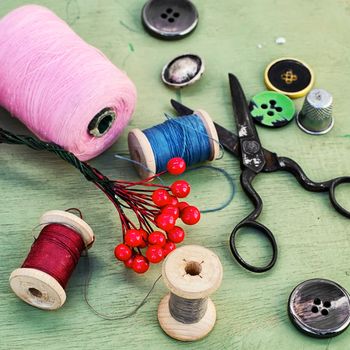 Thread for sewing,buttons and decoration on wooden background.