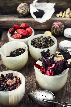 Tea leaves of different varieties in the stacks of custard and spoon