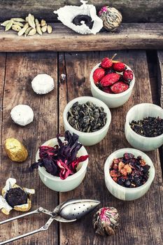 Tea leaves of different varieties in the stacks of custard and spoon