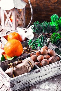 Decorative wooden box with hazelnuts,mandarins and gifts.