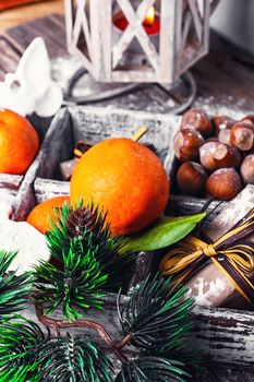 Decorative wooden box with hazelnuts,mandarins and gifts.