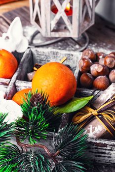 Decorative wooden box with hazelnuts,mandarins and gifts.