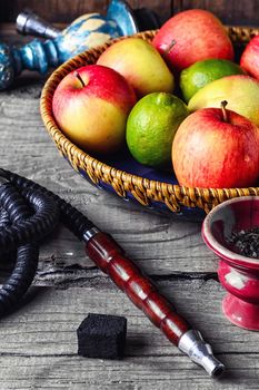 Smoking hookah and basket with apples,pomegranate and lime