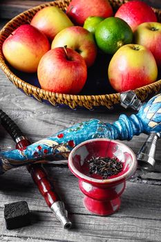 Smoking hookah and basket with apples,pomegranate and lime