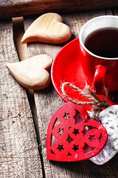 Red Cup with black coffee and two carved decorative wooden heart.Selective focus