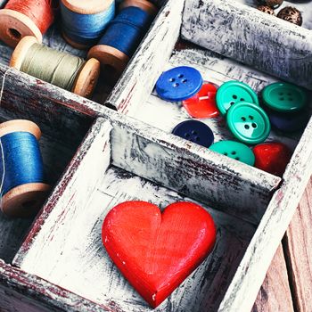 Wooden sewing box with threads,buttons and symbolic heart