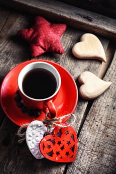 Red Cup with black coffee and two carved decorative wooden heart.Selective focus