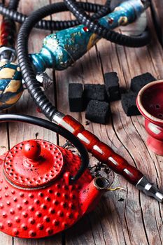 Details of Smoking hookah and red metal kettle spilled tea leaf
