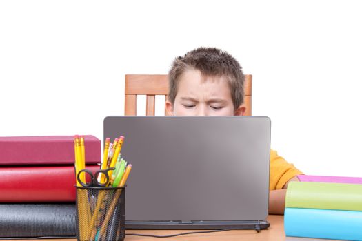 Top of head for single male child studying while surrounded with large books in front of laptop over white background