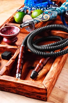 Wooden box with hookah smoking accessories and fruits of lime