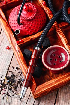 Details of smoking hookah,cast iron red teapot in wooden box