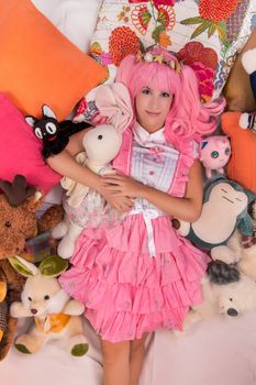 young girl in a bedroom in a pink cute dress