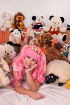 young girl in a bedroom in a pink cute dress