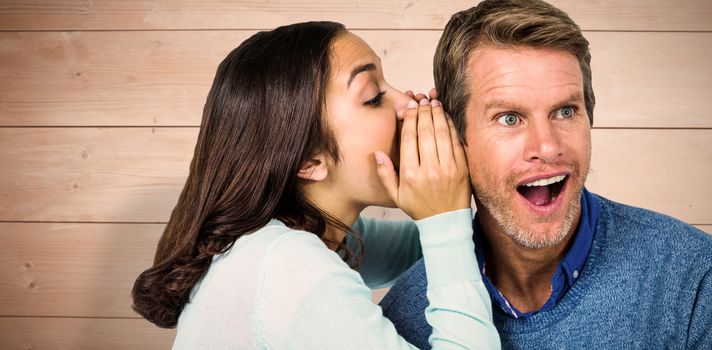 Woman whispering secret with man against overhead of wooden planks