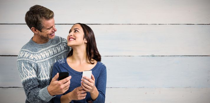 Happy romantic couple with mobile phone against painted blue wooden planks