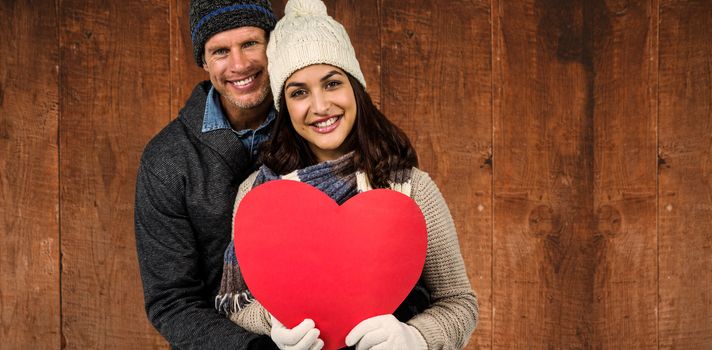 Festive couple in winter clothes  against weathered oak floor boards background