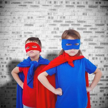 Masked kids pretending to be superheroes against grey brick wall