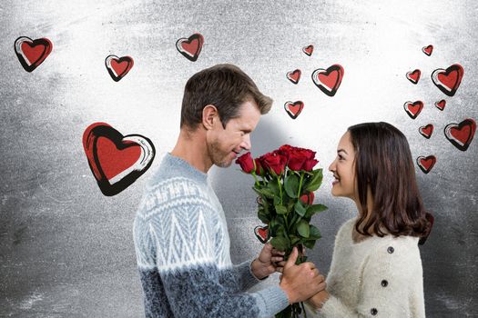 Romantic couple holding red roses against blackboard