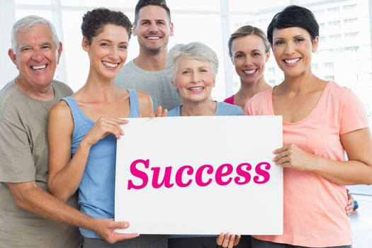 The word success and fit people holding blank board in yoga class against white angular design