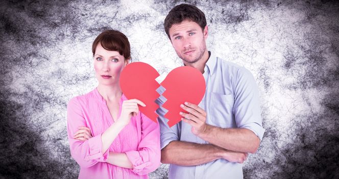 Couple holding a broken heart against grey background